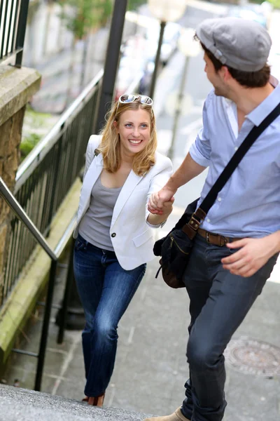 Young romantic couple climbing stairs in town — Stock Photo, Image
