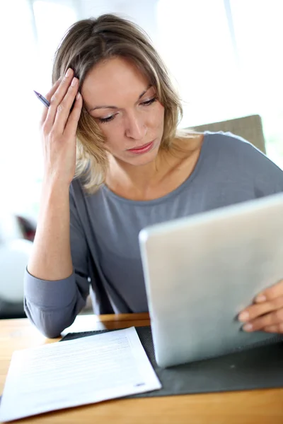 Mujer en casa que tiene problemas para llenar el formulario de impuestos —  Fotos de Stock