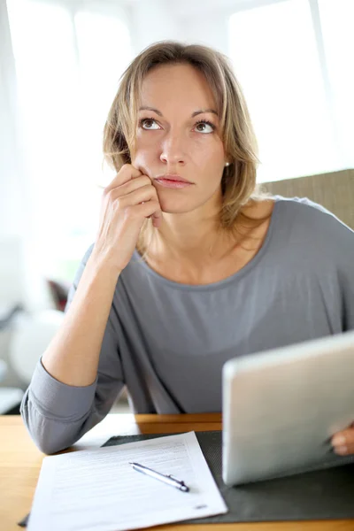 Mujer en casa que tiene problemas para llenar el formulario de impuestos — Foto de Stock