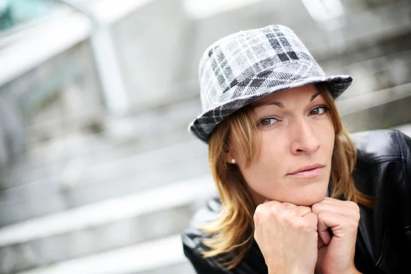 Retrato de mujer con sombrero y chaqueta de cuero en la ciudad — Foto de Stock