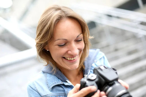 Vrouw met behulp van fotocamera in de stad — Stockfoto