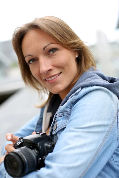 Vrouw met behulp van fotocamera in de stad — Stockfoto