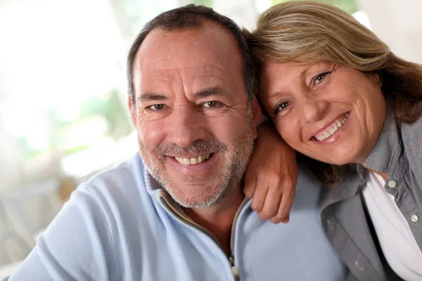 Retrato de casal sênior feliz sentado no sofá — Fotografia de Stock