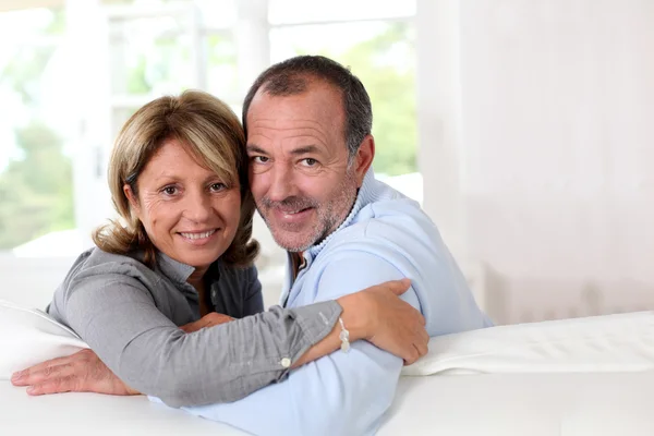 Retrato de feliz pareja de ancianos sentados en el sofá — Foto de Stock