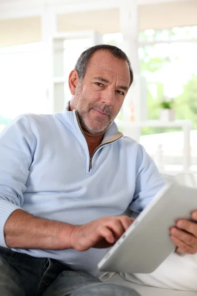 Senior férfi otthon segítségével elektronikus tabletta — Stock Fotó