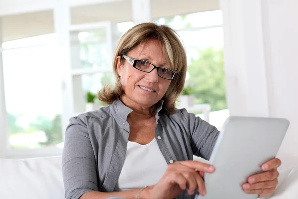 Mujer mayor sonriente en casa conectada a Internet — Foto de Stock