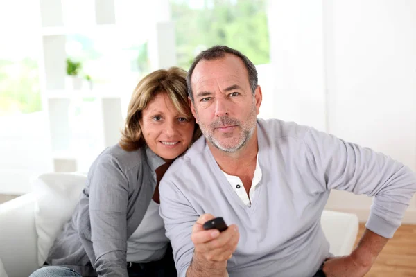 Casal sênior assistindo televisão em casa — Fotografia de Stock