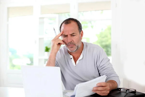 Senior man wordt verbaasd met belastingdocumenten — Stockfoto