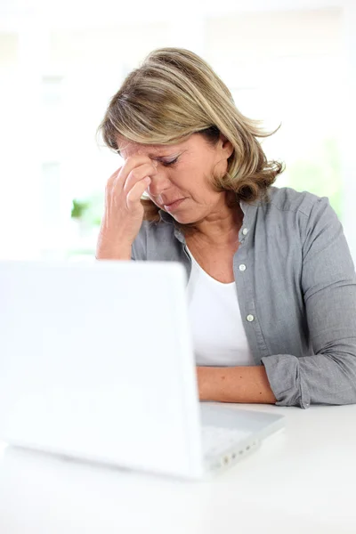 Senior kantoor werknemer met een migraine voor laptop — Stockfoto
