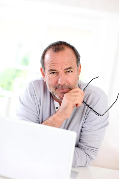 Старший бизнесмен работает на ноутбуке из дома — стоковое фото