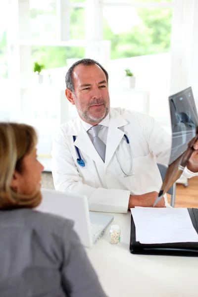 Médico con paciente mirando rayos X — Foto de Stock