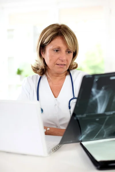 Mulher médico no escritório verificando XRay — Fotografia de Stock