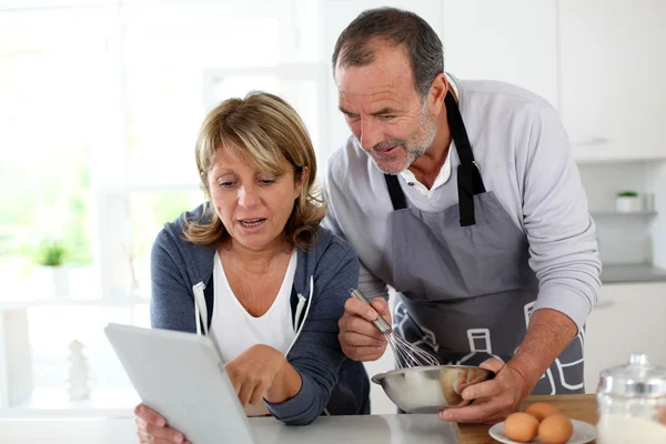 Casal sênior se divertindo em casa cozinha — Fotografia de Stock