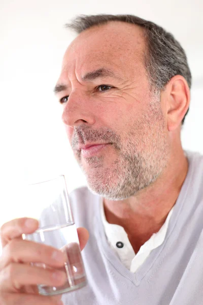 Uomo anziano che tiene un bicchiere d'acqua — Foto Stock