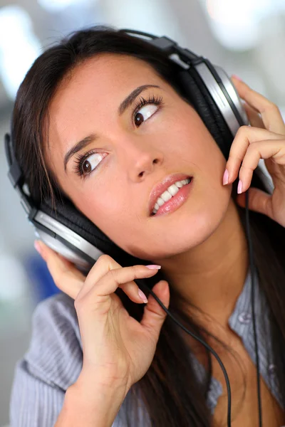 Vacker ung kvinna som lyssnar på musik Stockbild