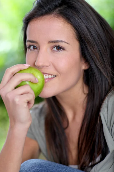 Portrait de femme assise dehors avec une pomme Images De Stock Libres De Droits