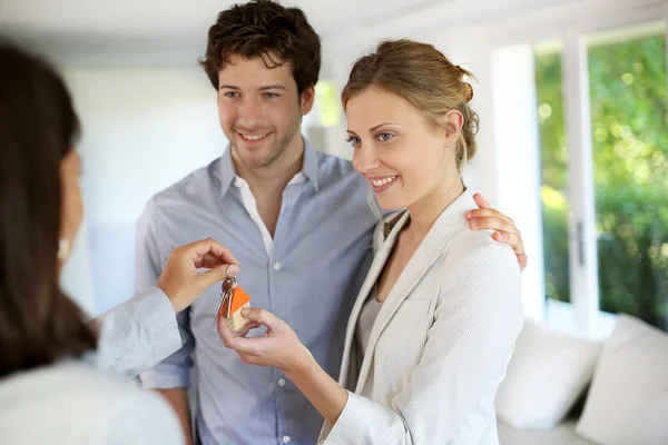 Feliz jovem casal recebendo chaves de sua nova casa Imagens Royalty-Free