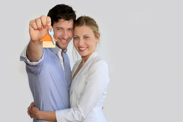 Jovem casal sorrindo segurando as chaves de sua nova casa Fotos De Bancos De Imagens