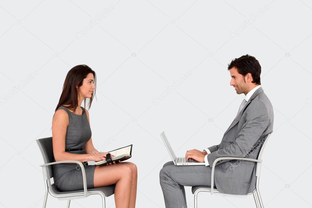 Business sitting face to face on grey background