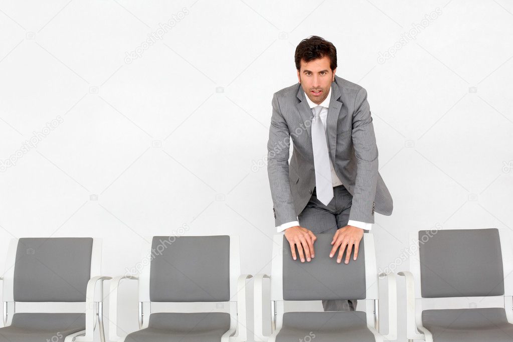 Man standing by chairs in waiting room