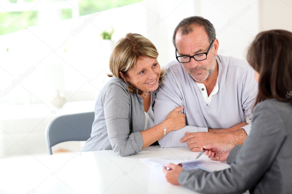 Senior couple signing financial contract