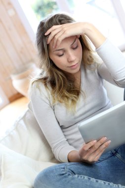 genç kadın şaşkın bir bakışla elektronik tablet arıyor