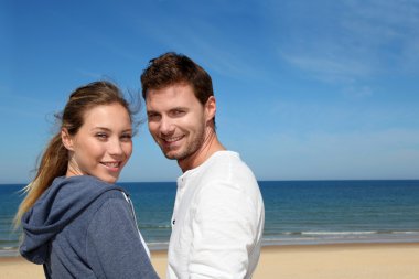 Portrait of happy couple at the beach clipart