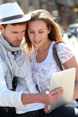Couple in town using electronic tablet