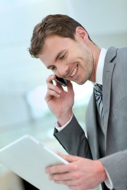 koridora inşaat telefon görüşmesini olan işadamı gülümseyen