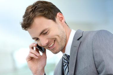 koridora inşaat telefon görüşmesini olan işadamı gülümseyen