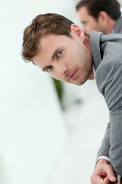 duvara yaslanmış gülümseyen işadamı portresi