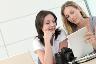 tablet ile ofiste çalışan kadın fotoğrafçılar