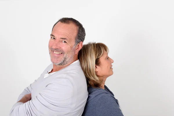 Seniorenpaar steht Rücken an Rücken auf weißem Hintergrund — Stockfoto
