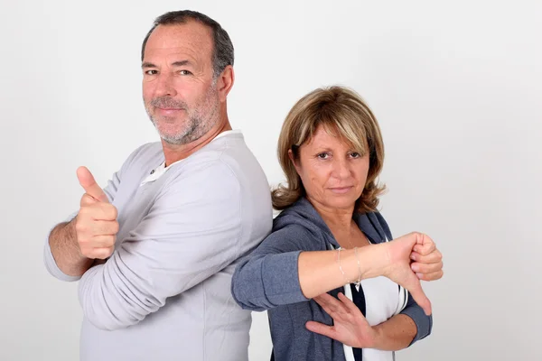 Senior couple with thumbs up and down — Stock Photo, Image