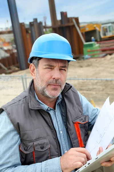 Gerente de construção controlando canteiro de obras com plano — Fotografia de Stock