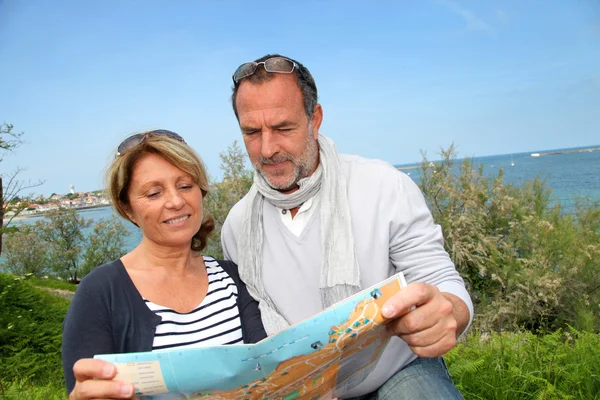 Coppia anziana in vacanza guardando la mappa della città — Foto Stock