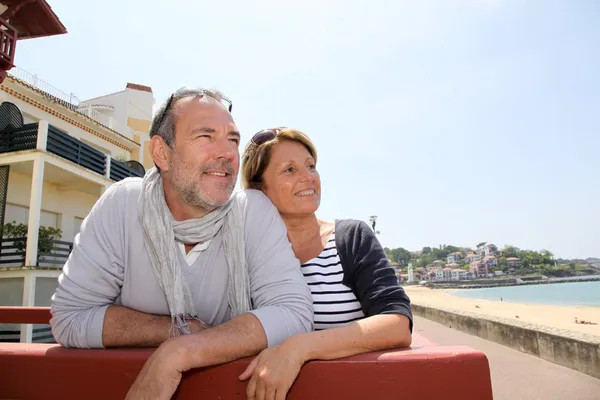 Coppia anziana in località balneare guardando la spiaggia — Foto Stock