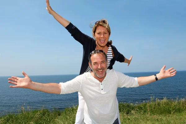 Allegro coppia stretching arms di fronte al mare — Foto Stock