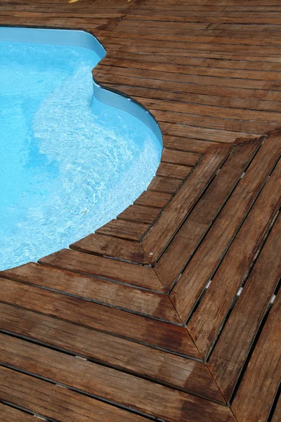 Closeup of swimming pool with wooden floor around — Stock Photo, Image