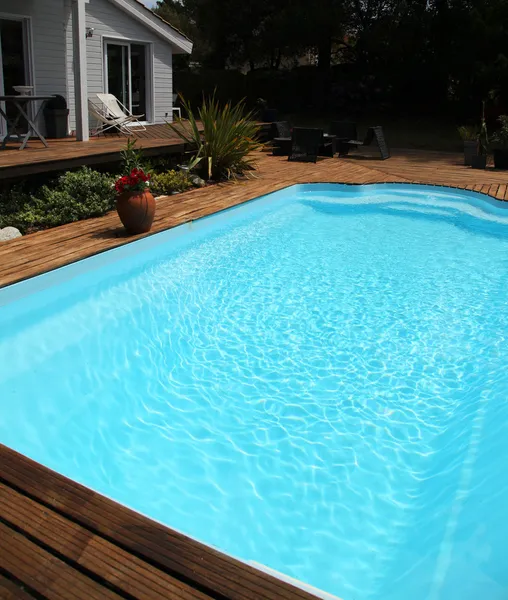 Fechar a piscina com piso de madeira ao redor — Fotografia de Stock