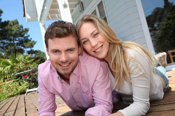 Porträtt av leende par stående framför huset — Stockfoto