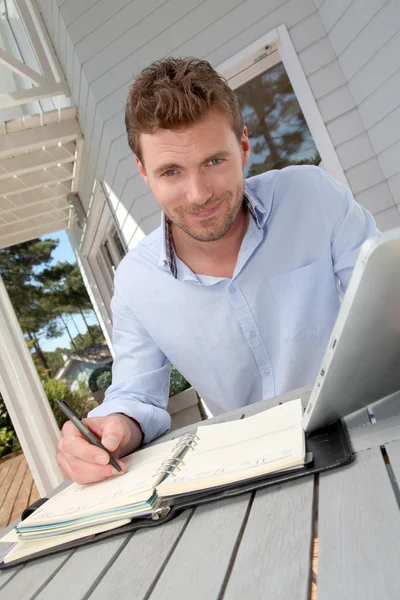 Retrato de homem sorridente trabalhando em casa em tablet — Fotografia de Stock