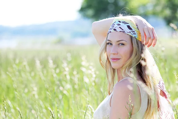 Beautiful blond woman in meadow with modern look — Stock Photo, Image