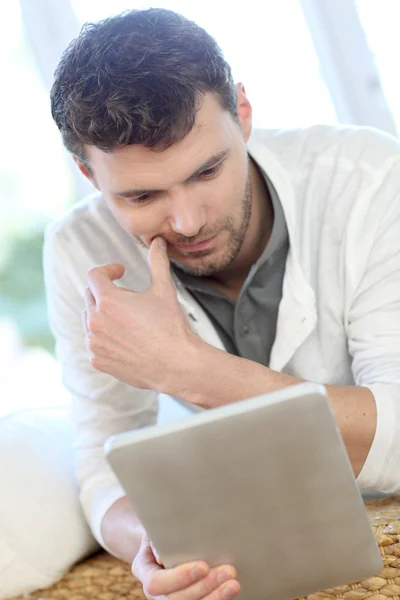 Homme assis dans le canapé avec tablette électronique — Photo