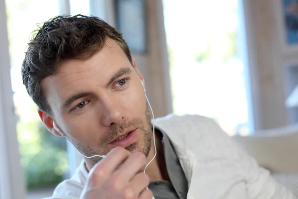 Young man talking on mobile phone with handsfree microphone — Stock Photo, Image