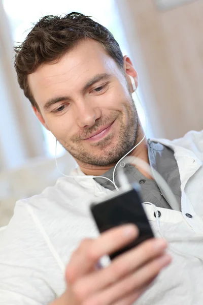 Portrait of young man listening to music with smartphone — Stock Photo, Image