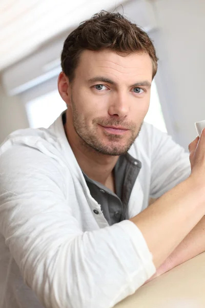 Portrait of handsome guy drinking coffee in home kitchen — Stock Photo, Image