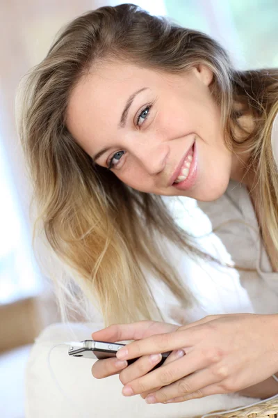 Веселая молодая женщина с помощью устройства громкой связи на мобильном телефоне — стоковое фото