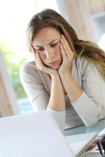 Mujer activa delante de la computadora portátil con aspecto molesto — Foto de Stock
