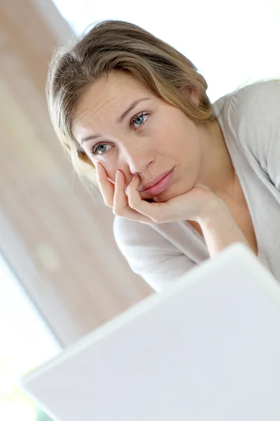 Mujer activa delante de la computadora portátil con aspecto molesto — Foto de Stock